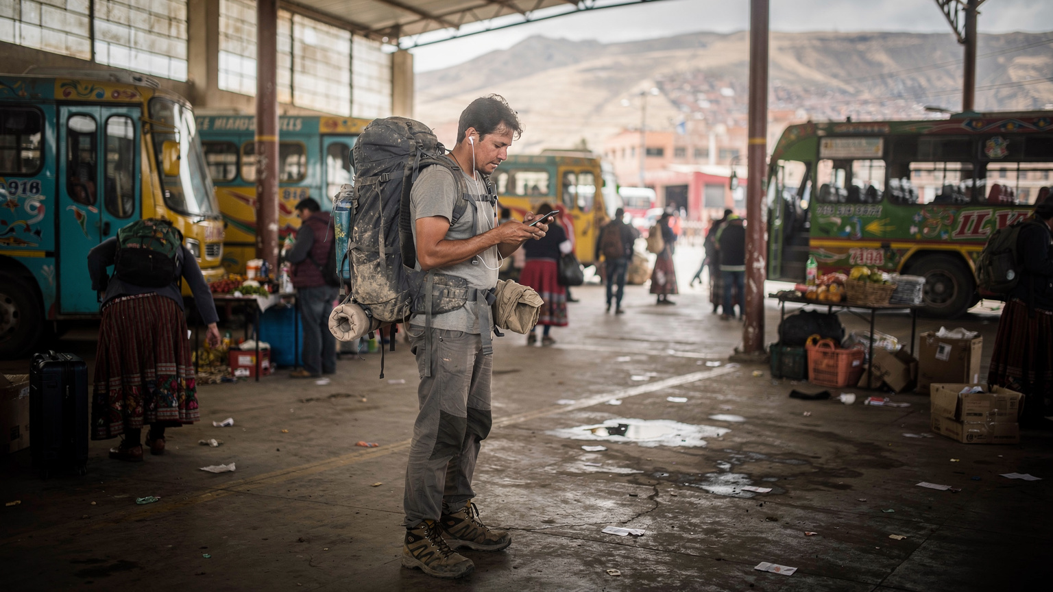 A traveler navigating a crowded local bus terminal in La Paz, Bolivia, with colourful public buses and people waiting to board.