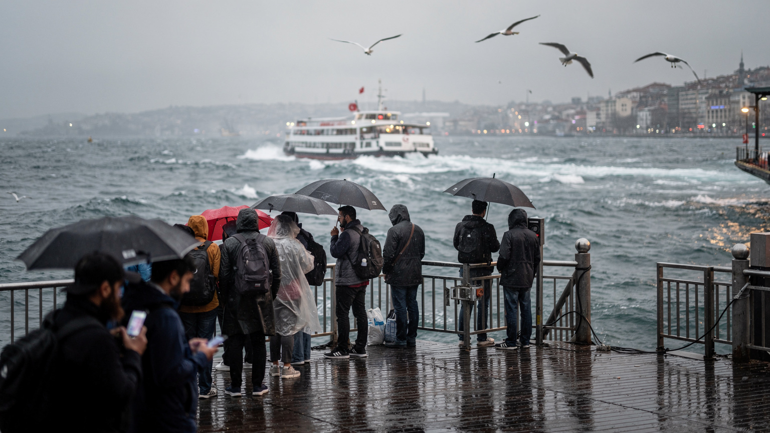 Banchina del traghetto a Kadıköy, Istanbul, con pendolari e viaggiatori che aspettano il vapur sotto la pioggia leggera