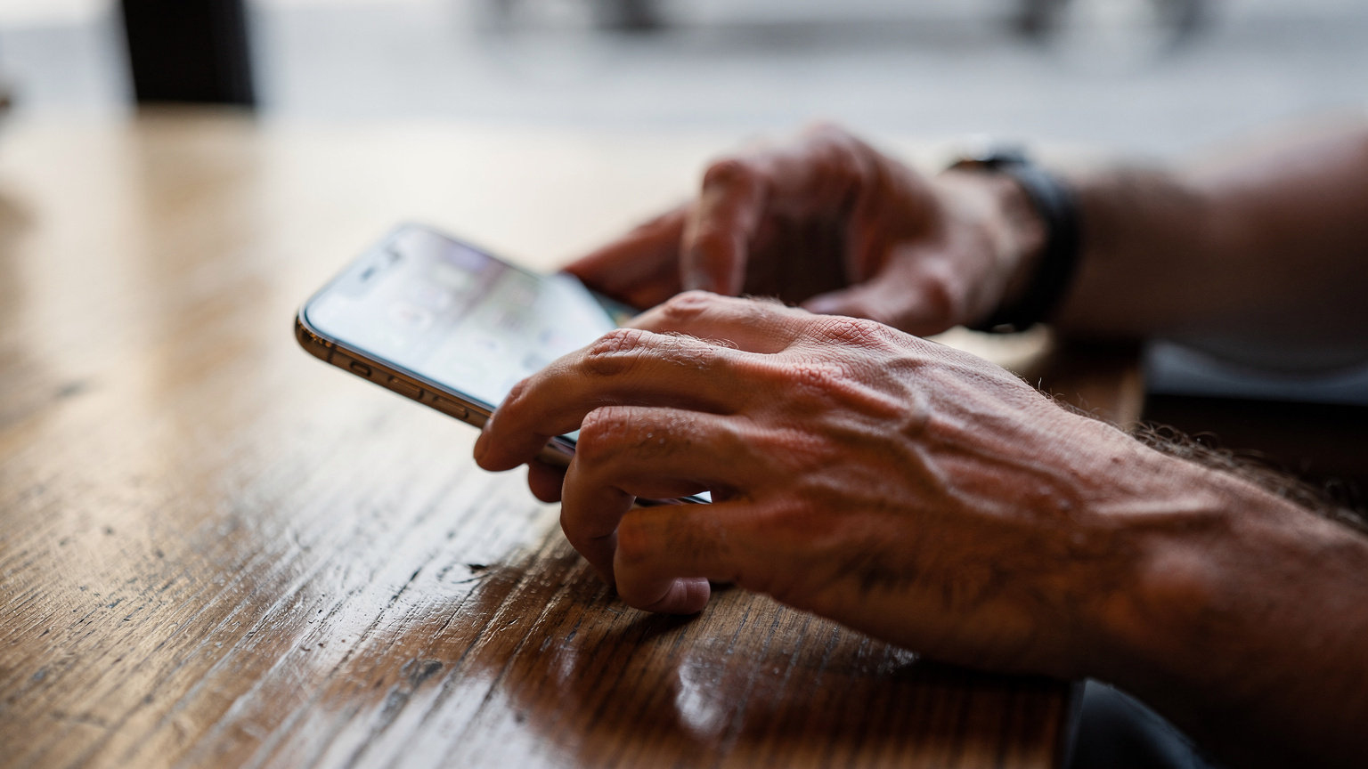 A close-up shot of human hands interacting with a smartphone screen, showing the gesture of swiping through digital settings, without any visible text or UI elements.