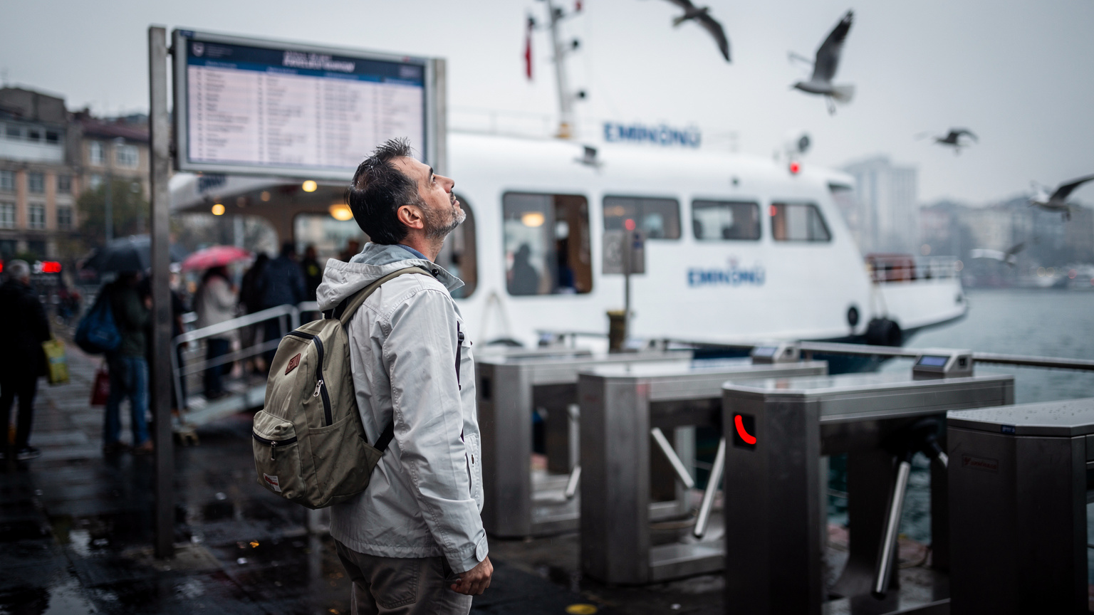 Passeggeri al terminal traghetti di Kadıköy con il ferry per Eminönü sullo sfondo