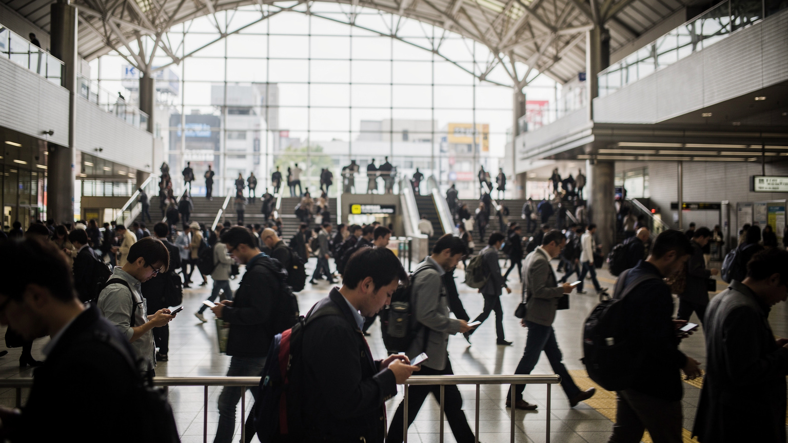 Vestíbulo de la estación de Shibuya en Tokio un martes por la mañana, con cientos de personas caminando y todas mirando sus teléfonos.