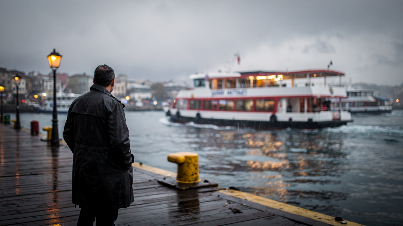 Molo di Kadıköy a Istanbul sotto la pioggia, con il traghetto Şehir Hatları in partenza