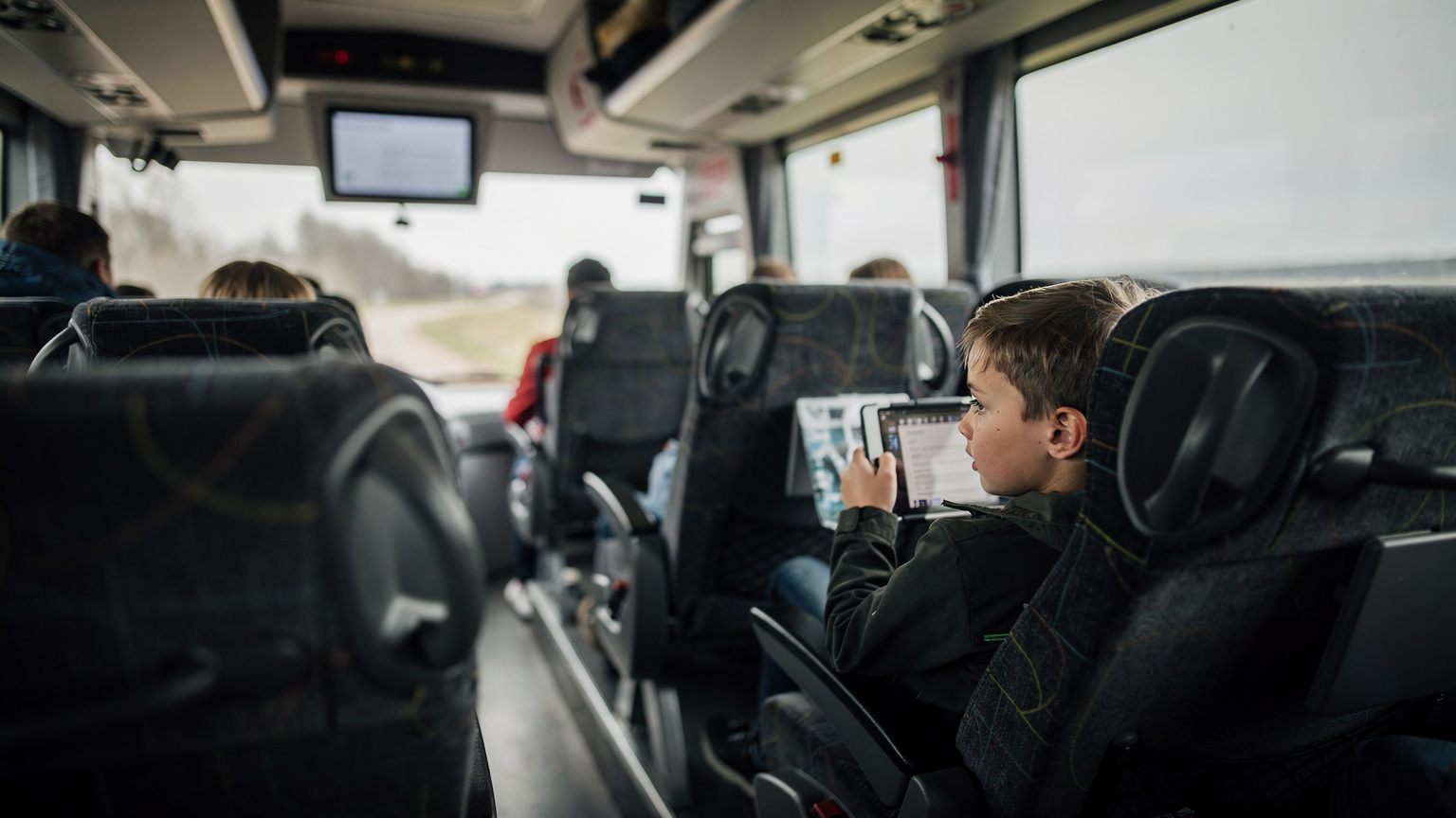 Moderne bus van Lux Express tussen Tartu en Tallinn, met stoelen en een scherm aan de muur