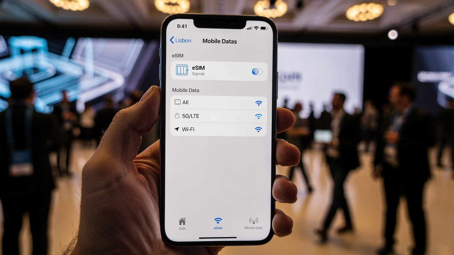 Een smartphone met een eSIM-profiel geactiveerd, met de achtergrond van een netwerkconferentie in Lissabon.