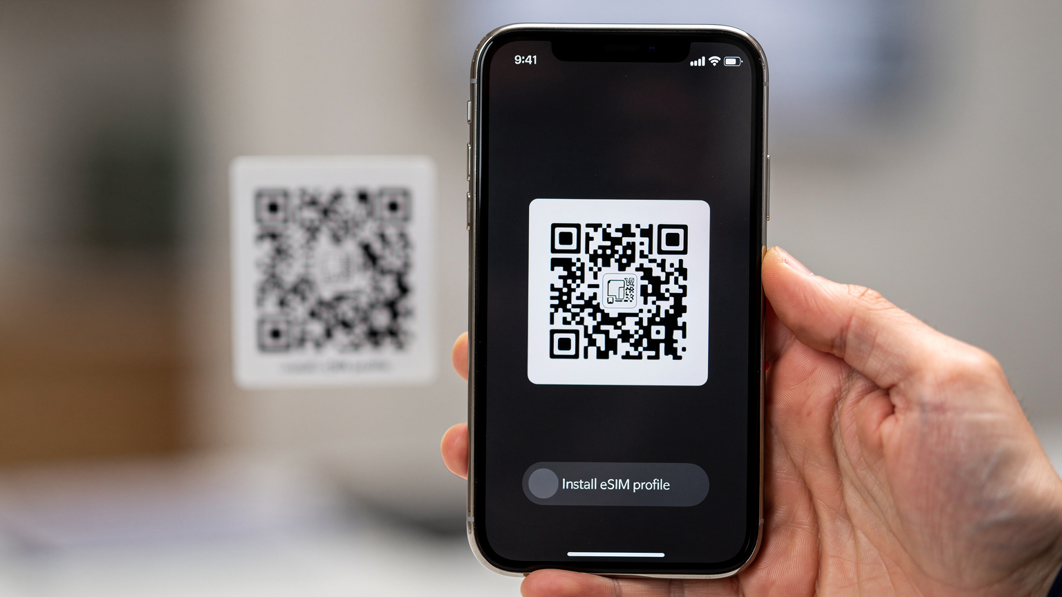 스마트폰으로 eSIM QR 코드를 스캔하여 설치하는 모습