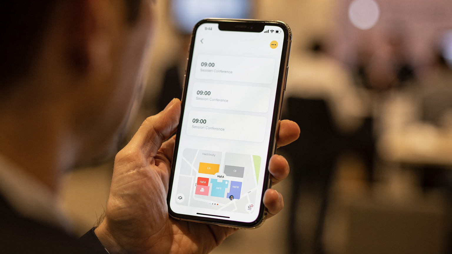 Un smartphone affichant une application de conférence avec des rendez-vous et un plan de l'événement, symbolisant la connectivité essentielle.
