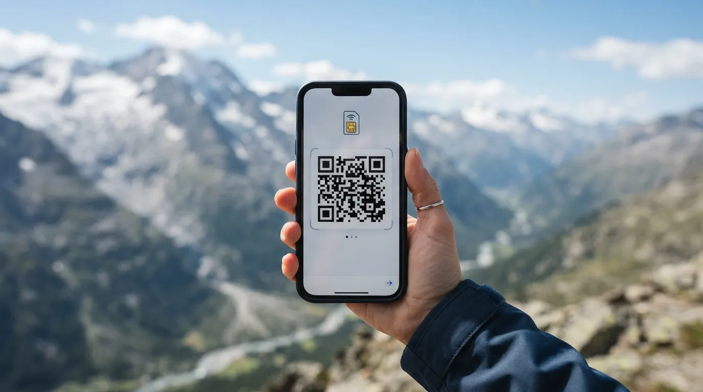 En hånd holder en smartphone, der viser en QR-kode på skærmen, klar til at scanne for eSIM-installation, med et bjerglandskab i baggrunden.