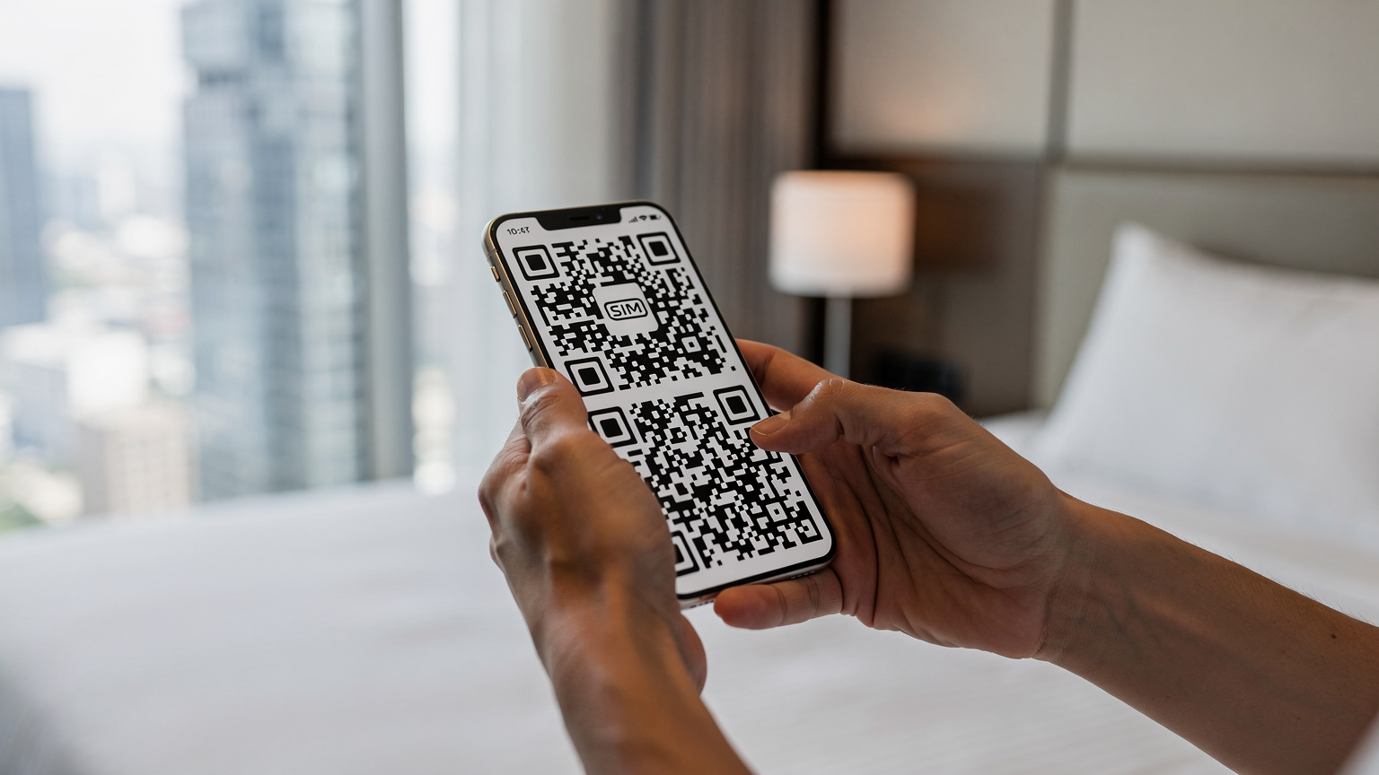 Close-up van handen die een smartphone vasthouden, waarbij een QR-code wordt gescand om een eSIM te activeren, met een wazige achtergrond van een hotelkamer in een moderne stad.