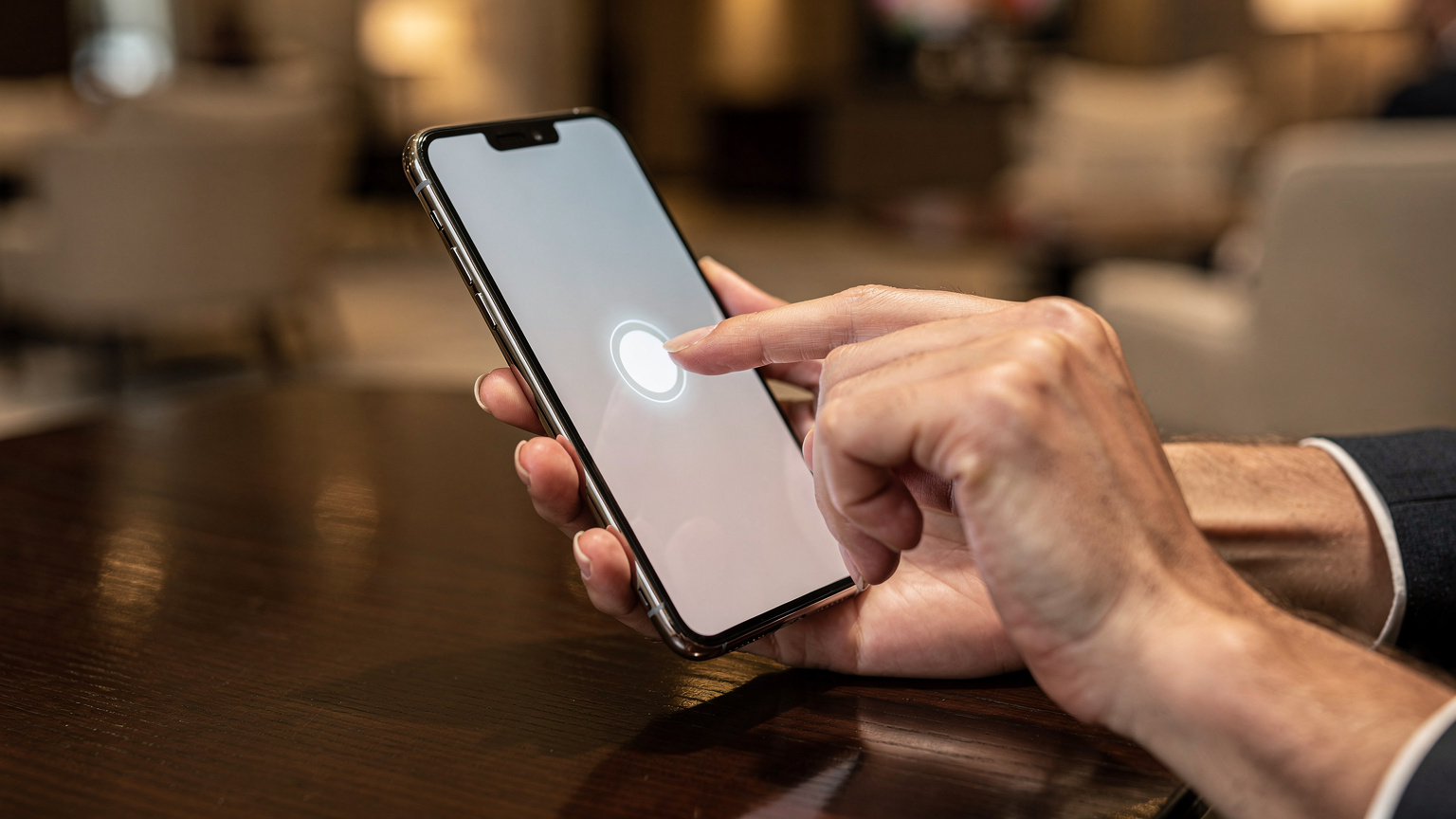 Close-up shot of hands holding a smartphone, with one finger gently tapping the screen to confirm an eSIM activation, showing the digital nature of the process.