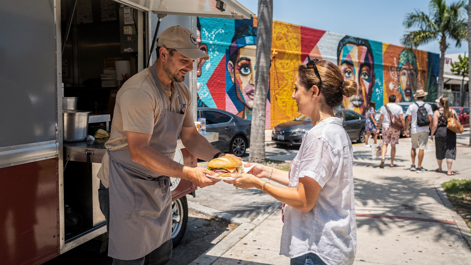 A vibrant street food vendor in Miami's Wynwood Arts District, serving Cuban sandwiches to art fair attendees, showcasing local culture.