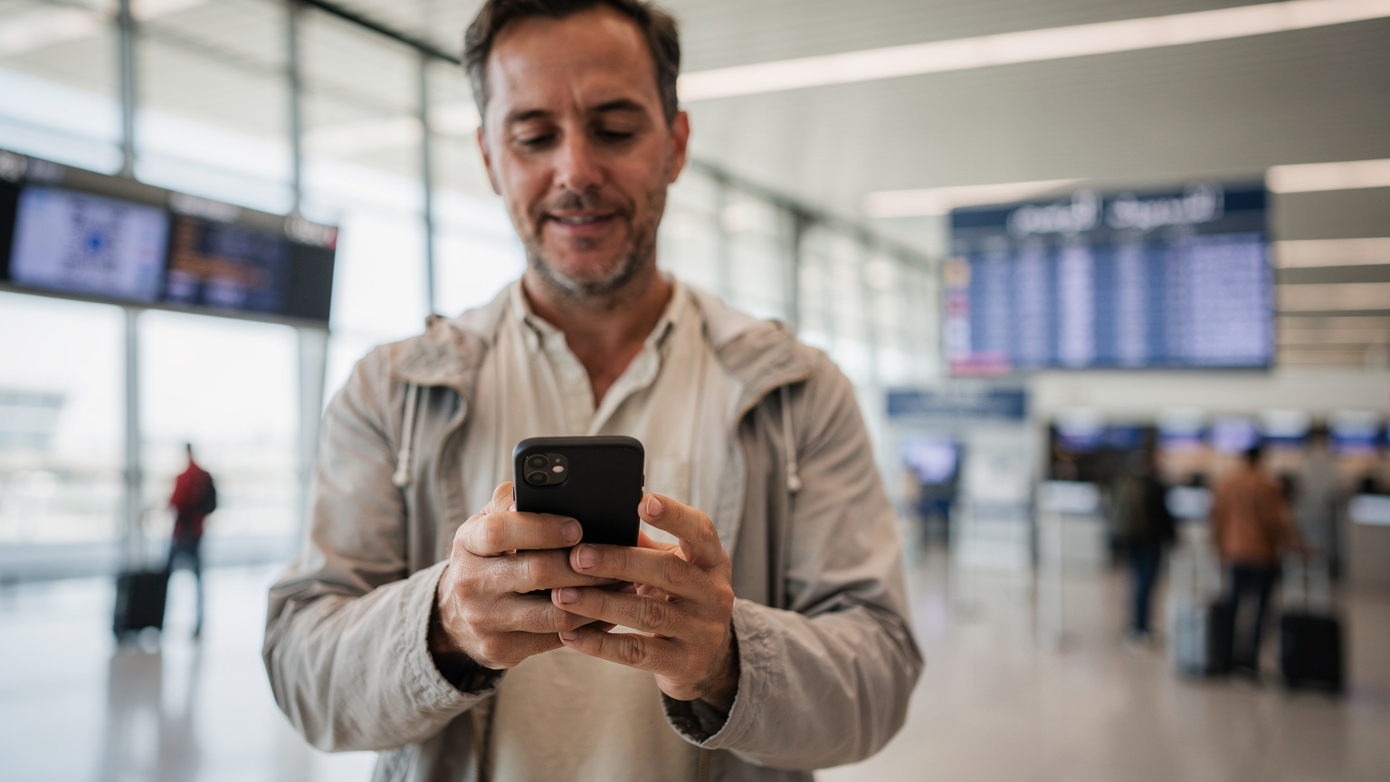 Людина легко сканує QR-код eSIM зі свого смартфона, стоячи в яскравому терміналі аеропорту Каїра.