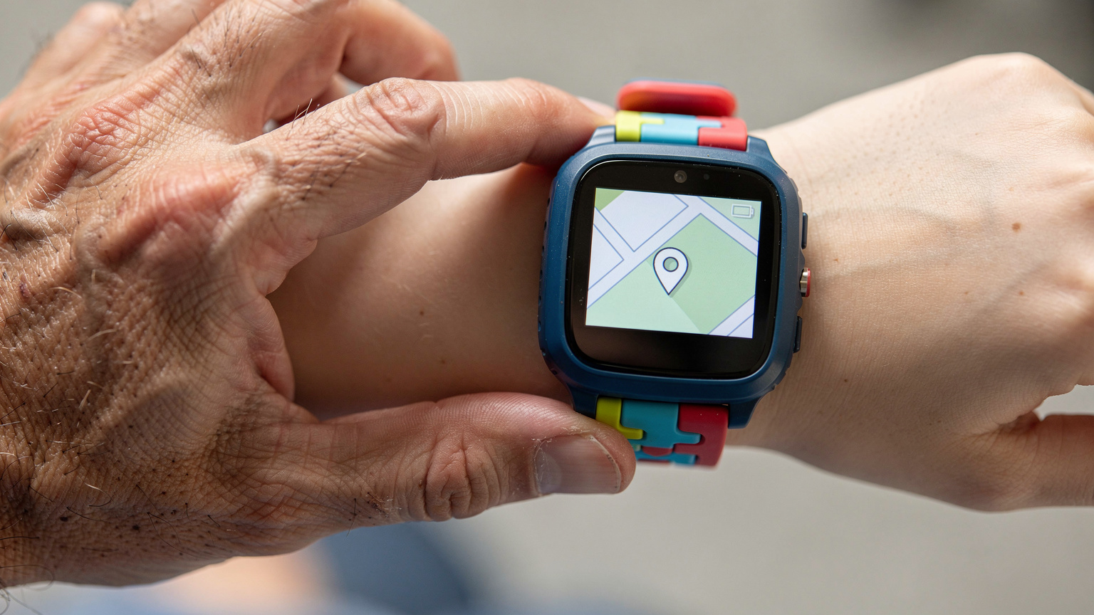 A close-up shot of a parent's hand gently touching a child's smartwatch, which displays a map with a location pin, demonstrating the use of eSIM for child tracking.
