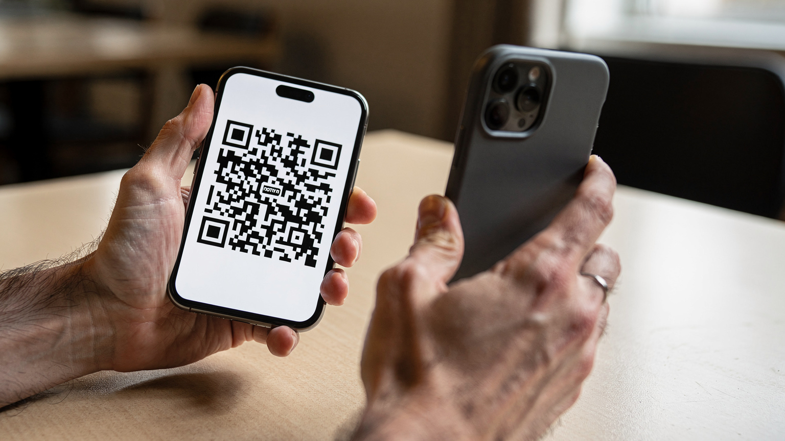 Zblízka na ľudské ruky držiace mobilný telefón, ukazujúce skenovanie QR kódu na aktiváciu eSIM.