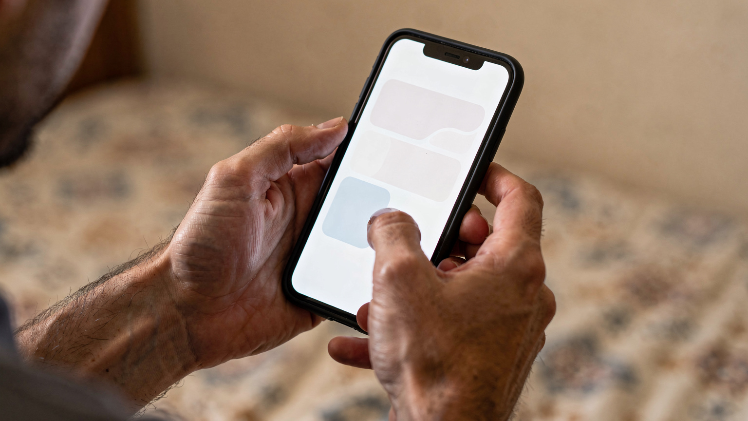 Detailní záběr rukou cestovatele, který v Hurghadě drží telefon s otevřenou aplikací pro eSIM, s lehkým zmateným výrazem, možná kontroluje nastavení nebo pokrytí.