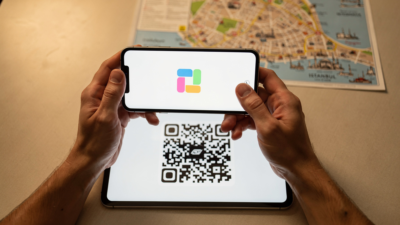 O ilustrare detaliată a mâinilor unei persoane care scanează un cod QR de pe un alt ecran pentru a activa un eSIM pe telefon, cu fundalul estompat al unei hărți turistice a Istanbulului.
