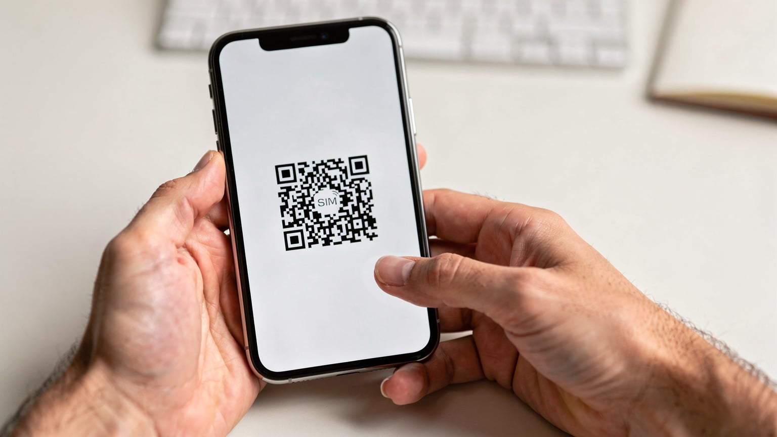 Een close-up van handen die een smartphone vasthouden, waarbij een QR-code voor eSIM-installatie op het scherm wordt gescand.