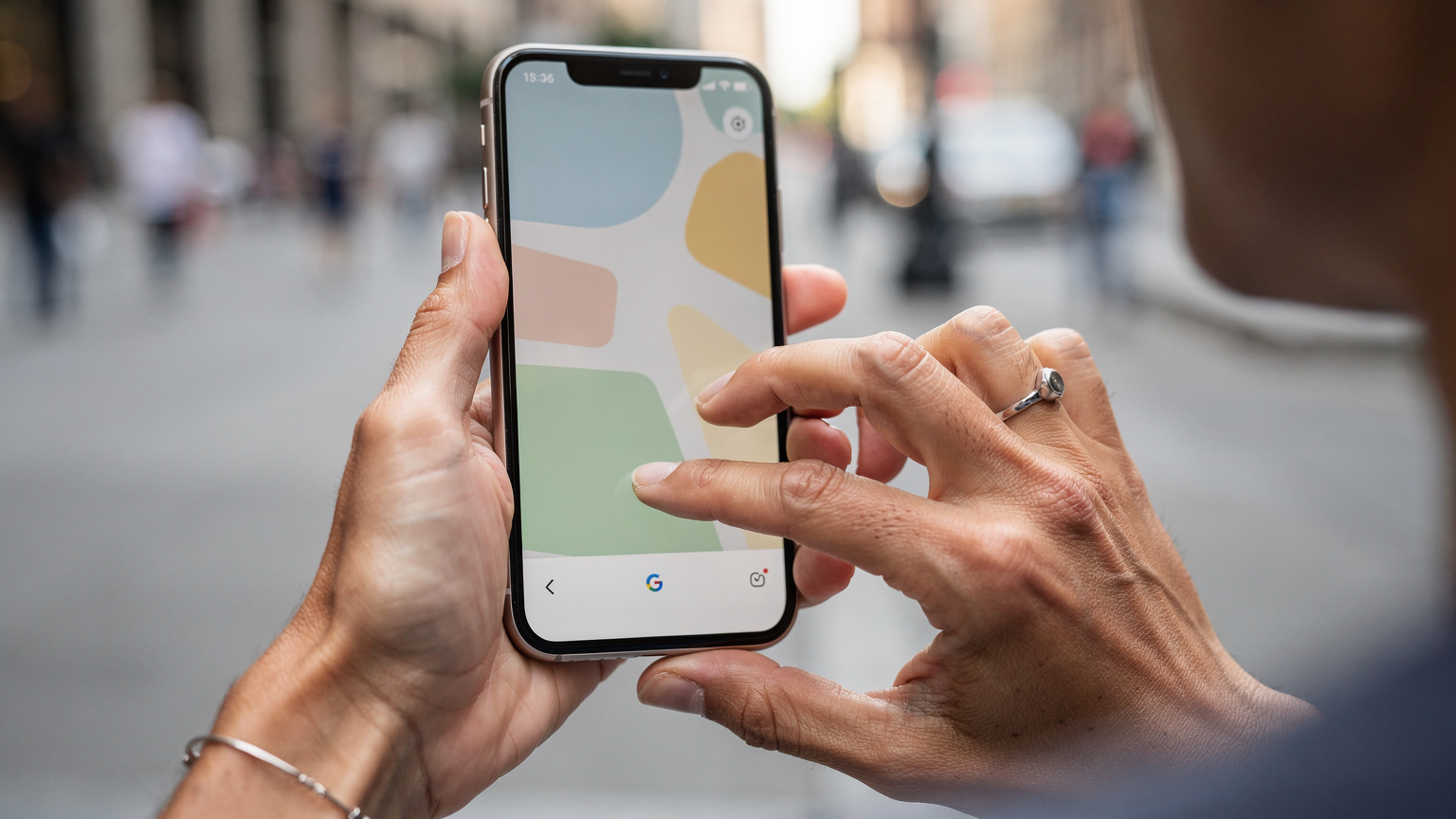 Una donna italiana sta tenendo in mano il suo smartphone, mostrato in un'inquadratura ravvicinata, mentre sta digitando con il pollice su una mappa di Google Maps, probabilmente per tracciare un percorso in una città degli Stati Uniti.