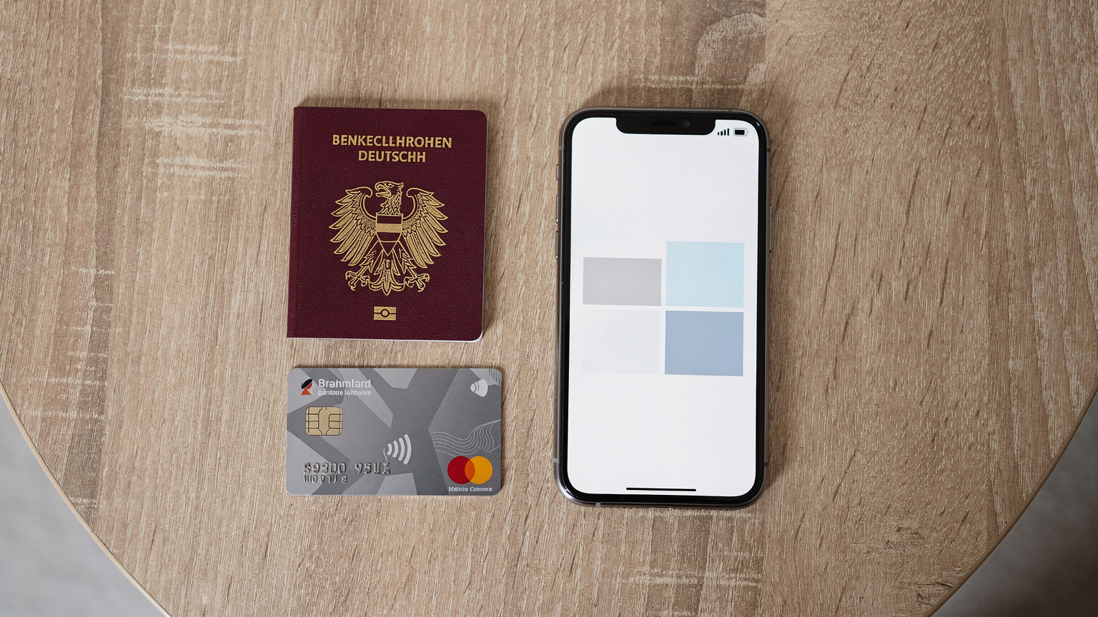 Ein Reisepass, eine Reisekreditkarte und ein Smartphone mit einer geöffneten Cellesim-App liegen auf einem Tisch. Die Szene vermittelt ein Gefühl von Sicherheit und Organisation beim Reisen.