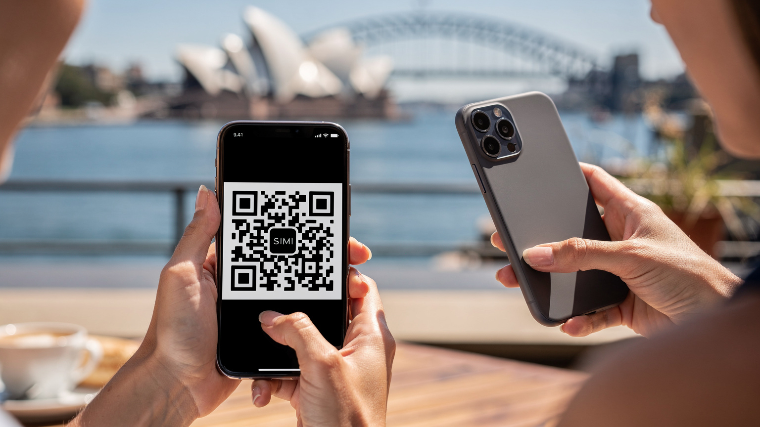 Một du khách đang cầm điện thoại thông minh và quét mã QR để kích hoạt eSIM tại một quán cà phê sân thượng ở Sydney, nhìn ra Nhà hát Opera Sydney.