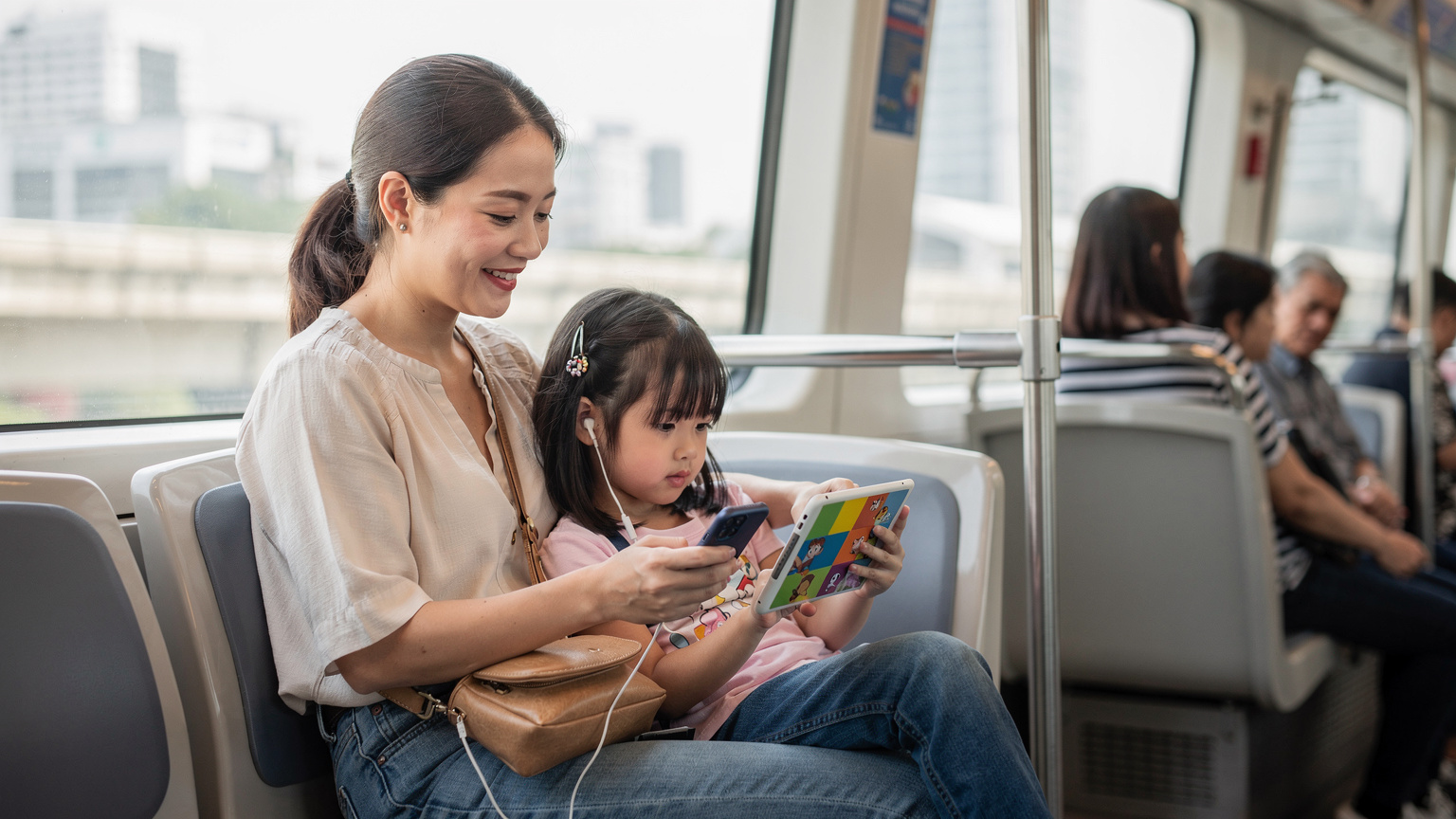 Một người mẹ Việt đang ngồi trên tàu điện ngầm ở Bangkok, cô ấy mỉm cười nhìn con gái 8 tuổi đang say sưa xem hoạt hình trên iPad, trong khi người mẹ đang kiểm tra điện thoại của mình với một giao diện ứng dụng quản lý eSIM.