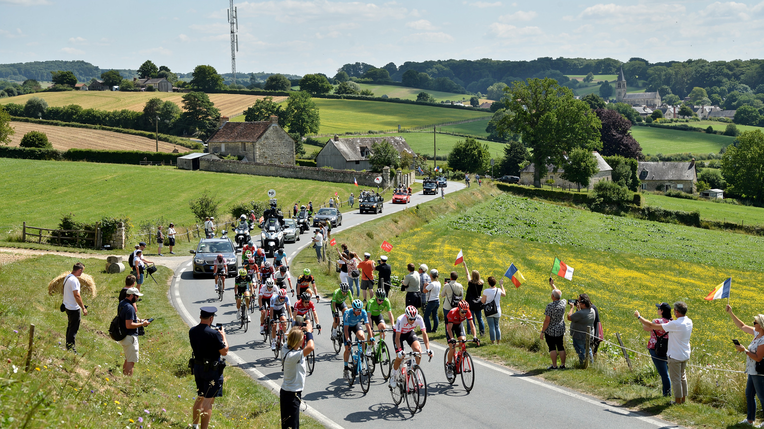 Een blik op de drukke wegen en de natuurlijke omgeving waar de Tour de France doorheen trekt, met mobiele zendmasten op de achtergrond die de connectiviteit garanderen.