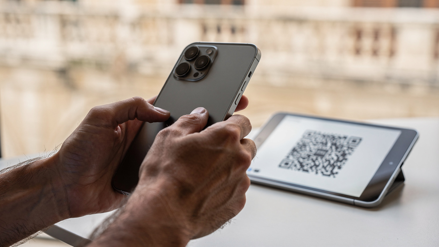 Zblízka na ruce cestovatele, který na moderním smartphonu skenuje QR kód pro aktivaci eSIM, s jasným a ostrým obrazem.