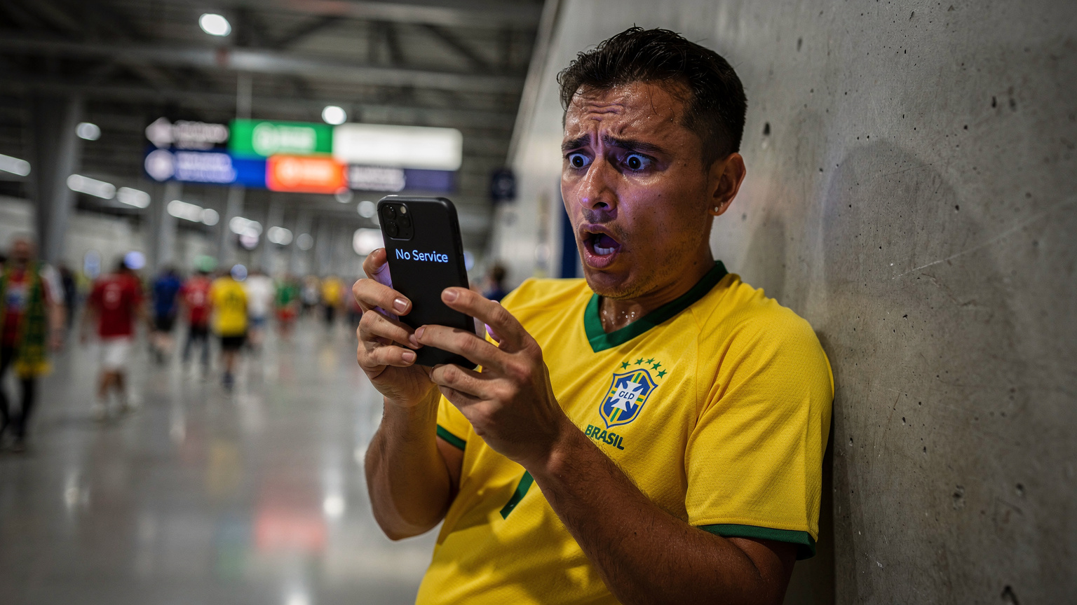 Um torcedor frustrado, com a camisa da seleção brasileira, tenta desesperadamente usar seu celular que exibe 'Sem Serviço', encostado em uma parede de concreto cinza no corredor de um estádio de futebol moderno, como o SoFi Stadium em Inglewood, Califórnia, durante um jogo da Copa do Mundo, com a multidão ao fundo. A iluminação é artificial e um pouco escura.
