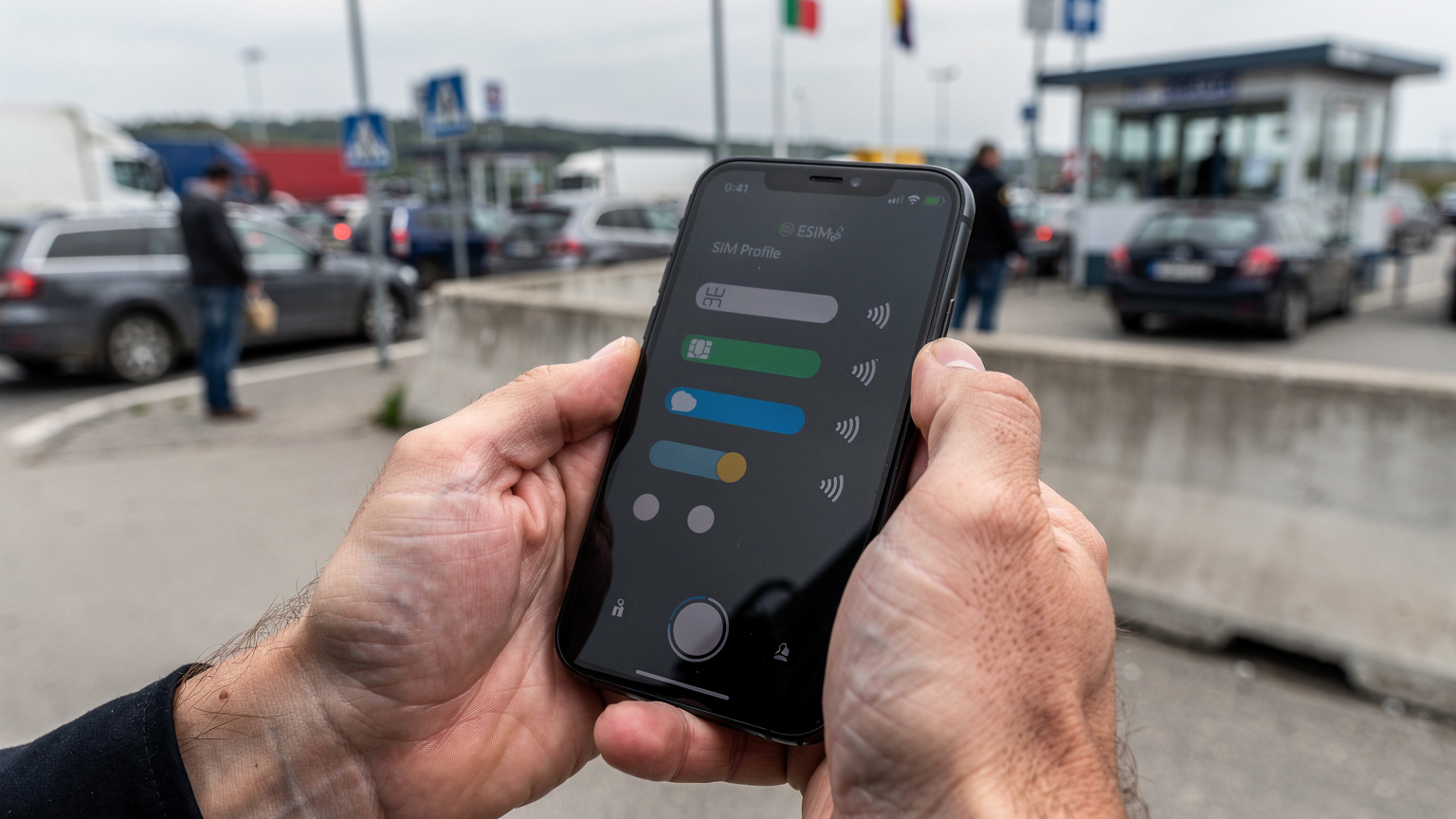 Ръце държат смартфон с активиран eSIM профил, докато чакат на опашка на оживен граничен пункт.