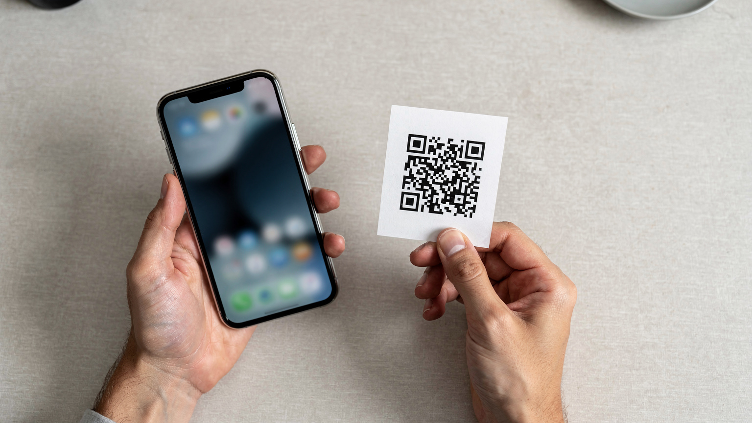 Крупный план рук, которые держат смартфон с открытым приложением Cellesim и сканируют QR-код eSIM для активации.