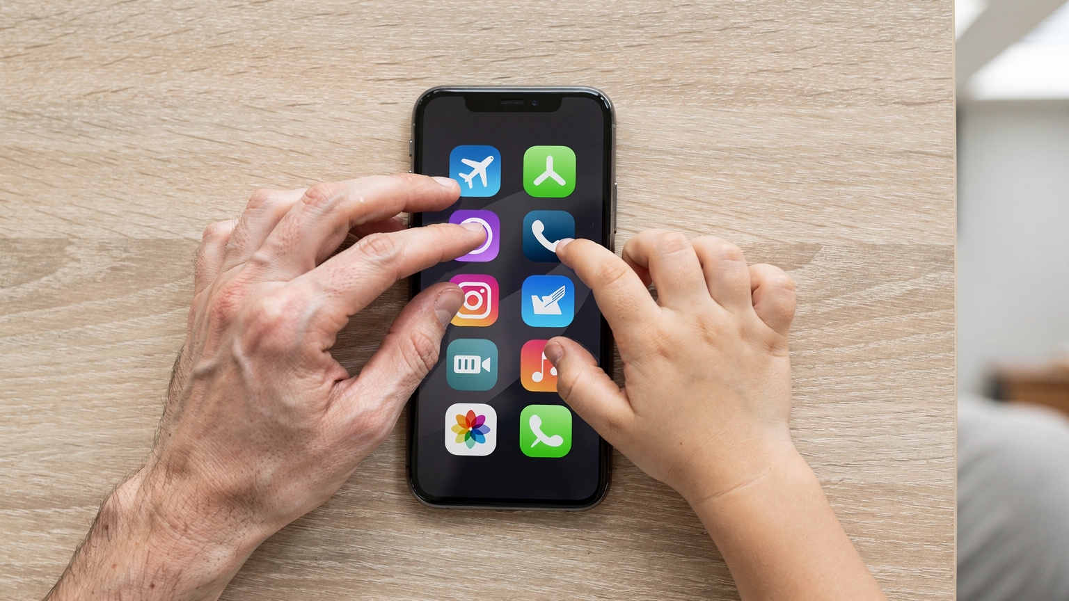 Un gros plan sur des mains d'adultes et d'enfants interagissant avec un iPhone. L'écran affiche des icônes d'applications de voyage et de contrôle parental, avec des doigts qui tapotent et glissent, illustrant la facilité de gestion des eSIM et des applications familiales.