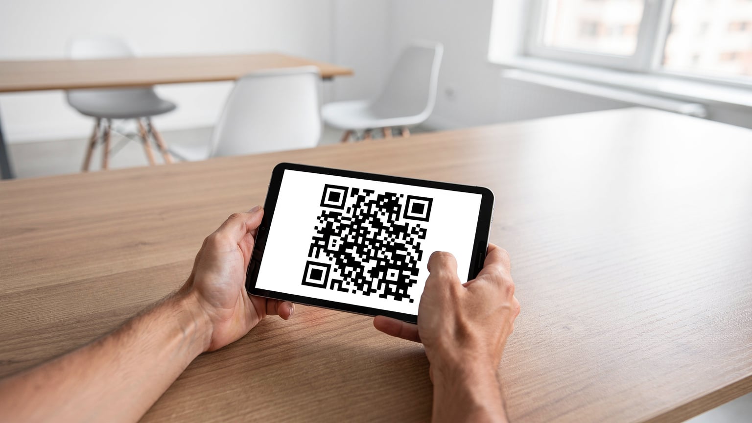 Κοντινό πλάνο ενός ατόμου που σαρώνει ένα QR code για την ενεργοποίηση μιας eSIM στο smartphone του, με φόντο έναν φωτεινό, μοντέρνο χώρο co-working στους Αγίους Σαράντα, υποδηλώνοντας εύκολη σύνδεση για ψηφιακούς νομάδες.
