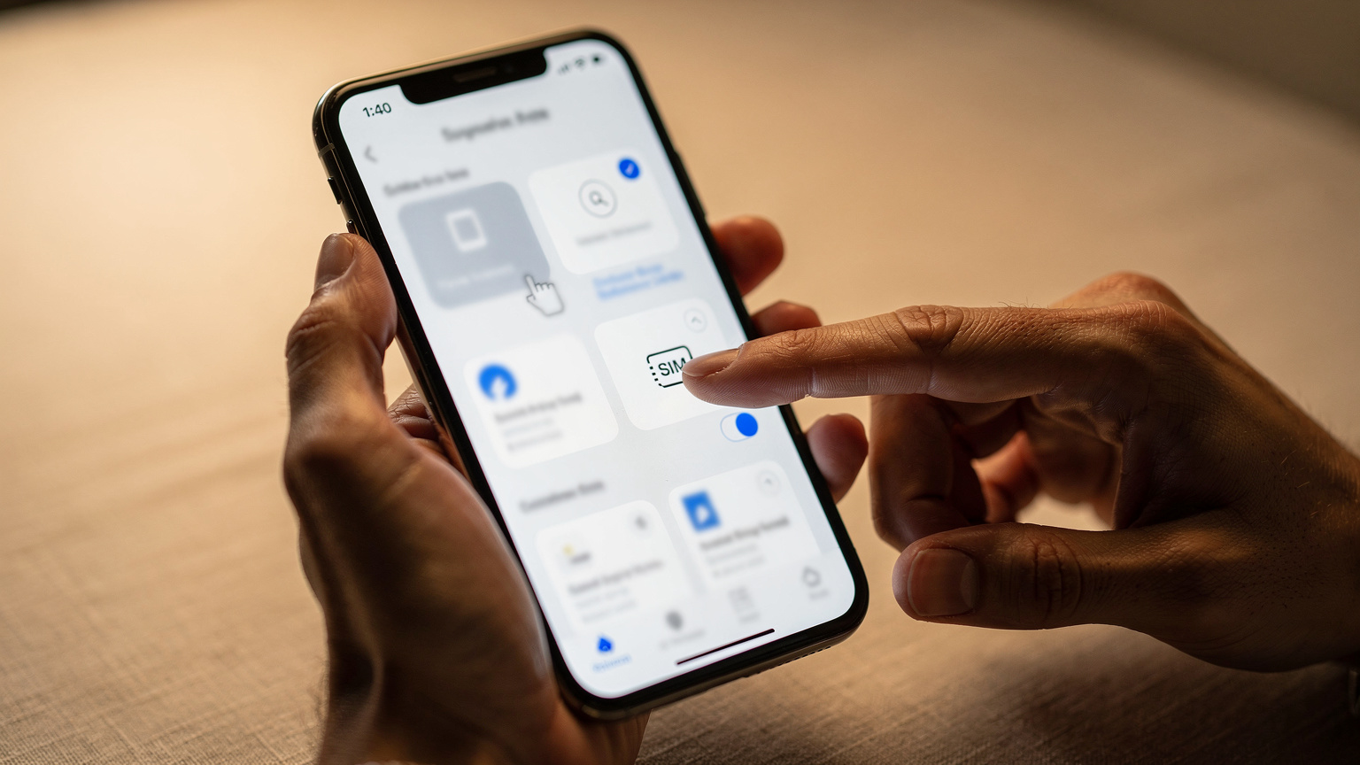 Gros plan sur des mains utilisant un iPhone pour naviguer dans les réglages de données cellulaires, avec un doigt tapotant l'option de transfert d'eSIM.