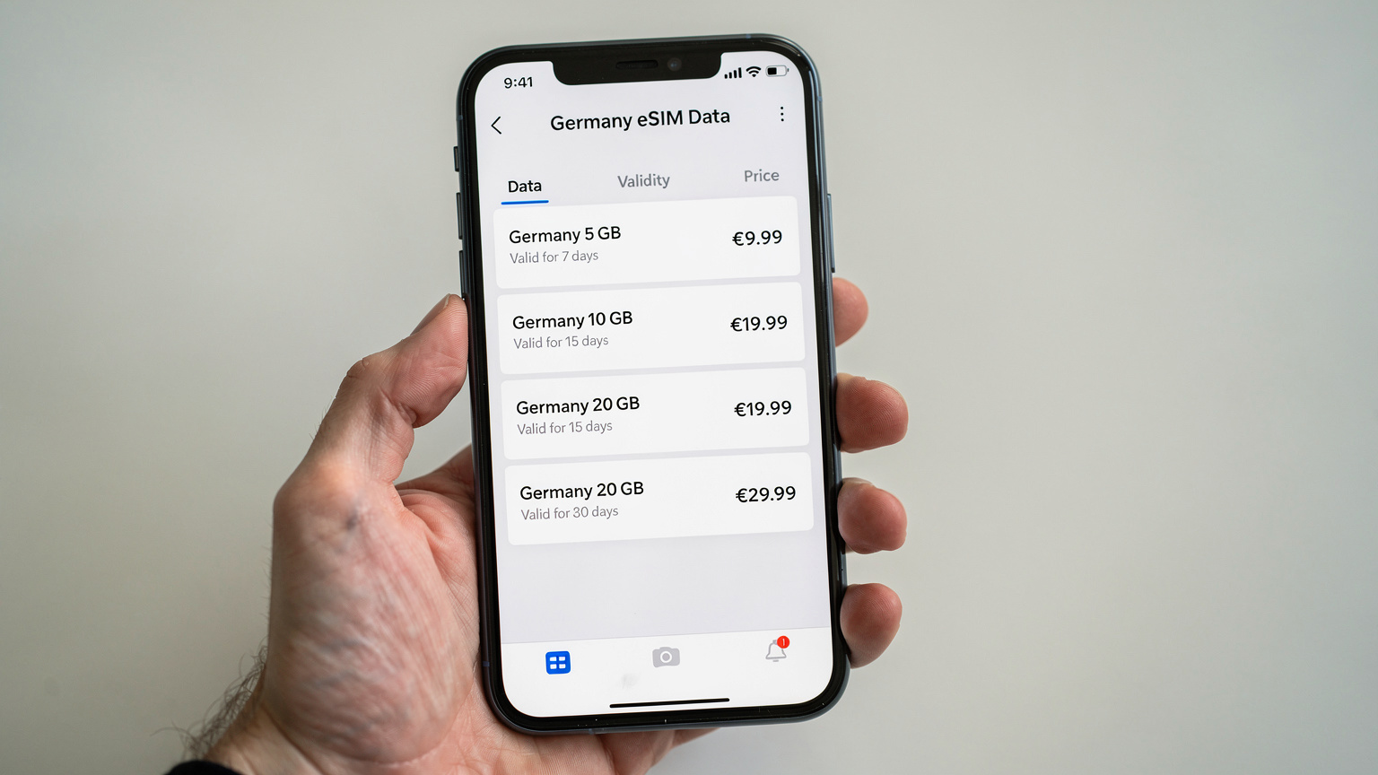 Nahaufnahme eines Smartphones, auf dem eine eSIM-App geöffnet ist, die verschiedene Datenpakete und ihre Preise für Deutschland anzeigt.