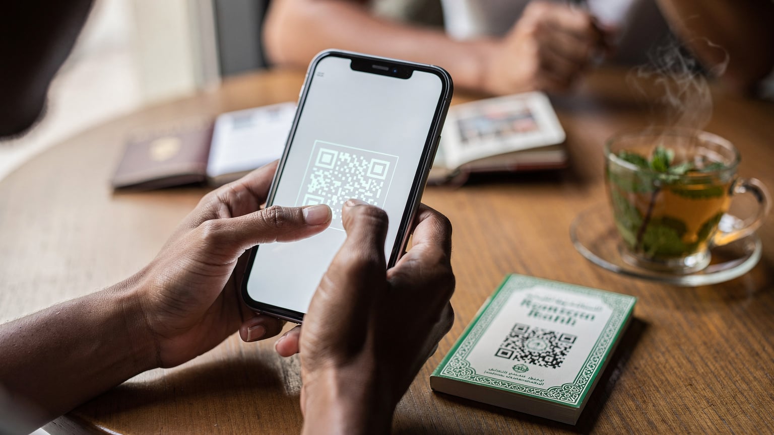 A close-up of a traveler's hands interacting with a smartphone screen, showing the process of scanning an eSIM QR code against a backdrop of travel essentials.
