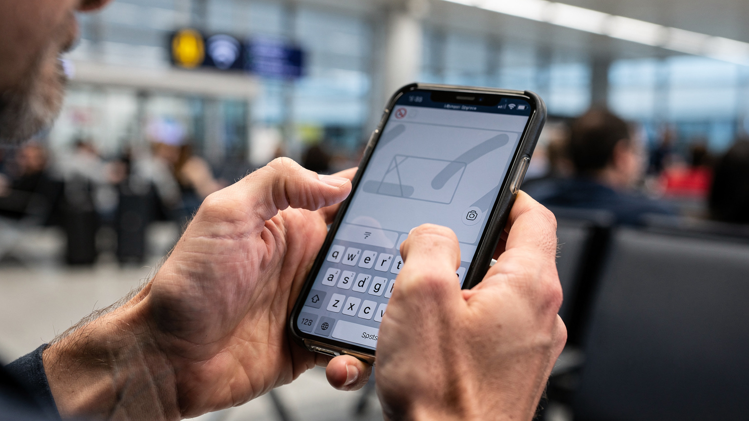 Зблизька знімок екрана смартфона, що показує налаштування APN з полем для введення тексту, а руки людини намагаються ввести необхідні дані, можливо, в громадському місці з поганим Wi-Fi.