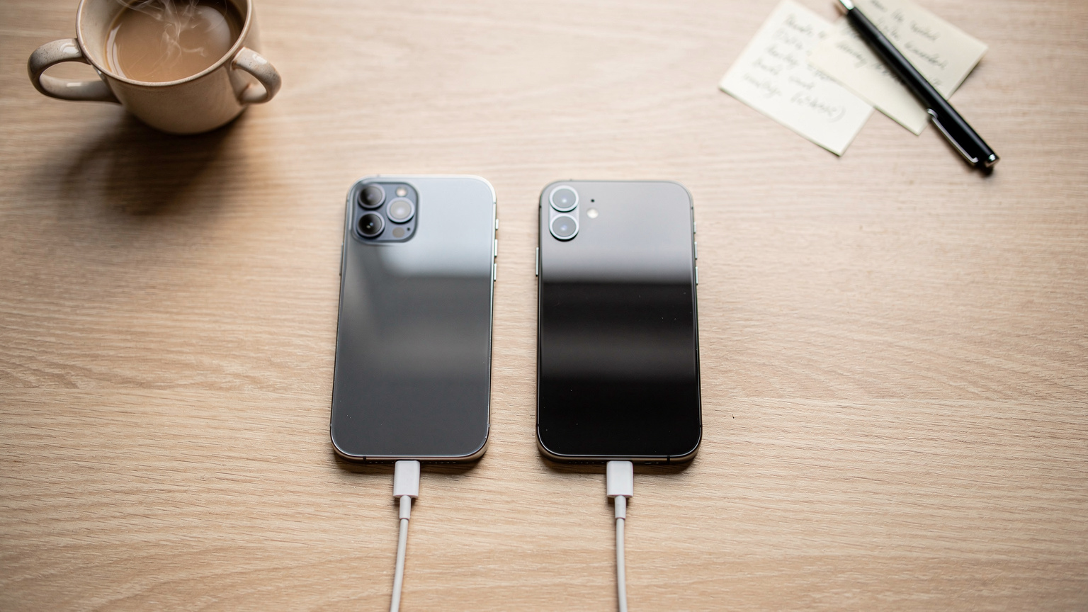 Een georganiseerde werkplek met een nieuwe iPhone naast een oudere, beide aangesloten op opladers, klaar voor een eSIM-overdracht, met een kop koffie en notities op de achtergrond.