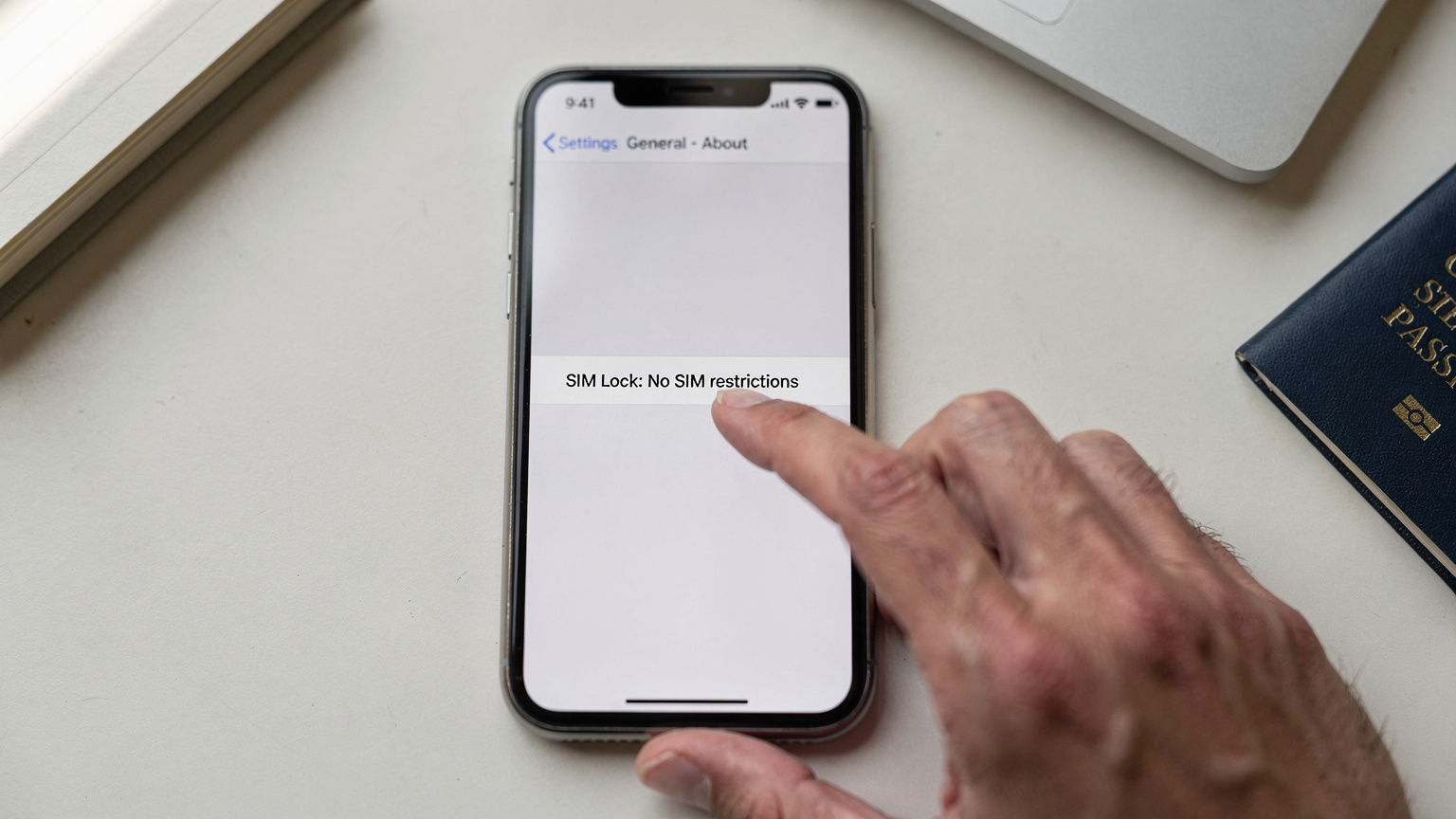 iPhoneの設定アプリで「SIMロックなし」と表示されている画面のクローズアップ。指が画面をスクロールしている。