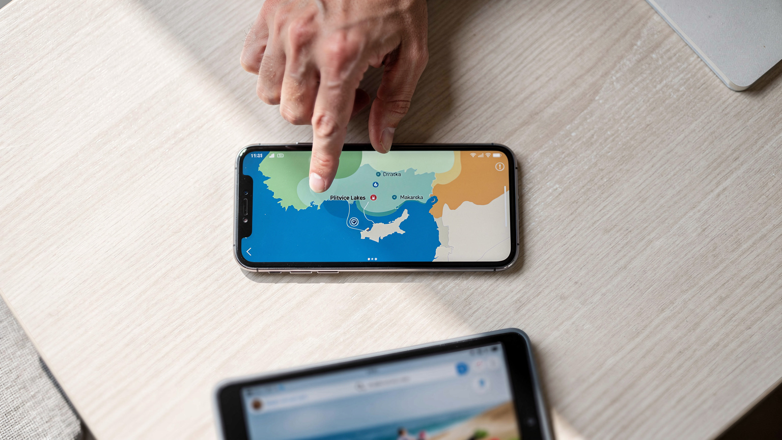 Digitální mapa Chorvatska s vyznačenými oblastmi pokrytí sítě a ikonami pro Plitvice a Makarskou, s rozmazaným náznakem ruky dospělého a tabletu dítěte v popředí.