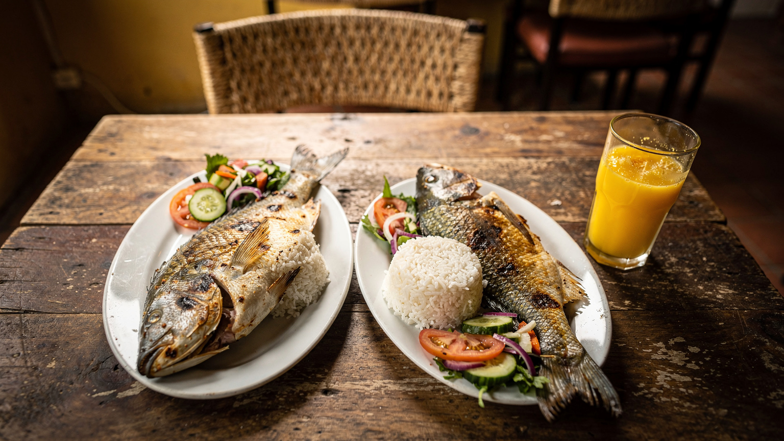 Uma mesa de jantar em um restaurante simples em Galápagos com pratos de peixe fresco e vegetais, com um ambiente acolhedor e rústico.