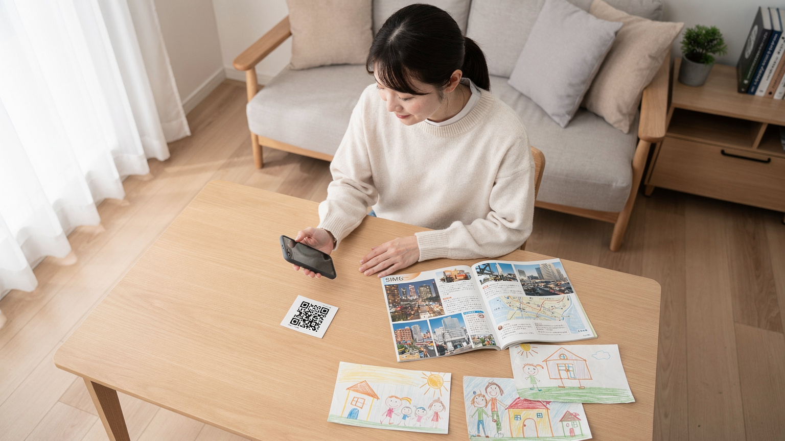母親が自宅のリビングで、落ち着いてスマートフォンのeSIM設定画面を開き、QRコードをスキャンしている。隣には、旅行ガイドブックと子供たちの描いた絵が置かれている。
