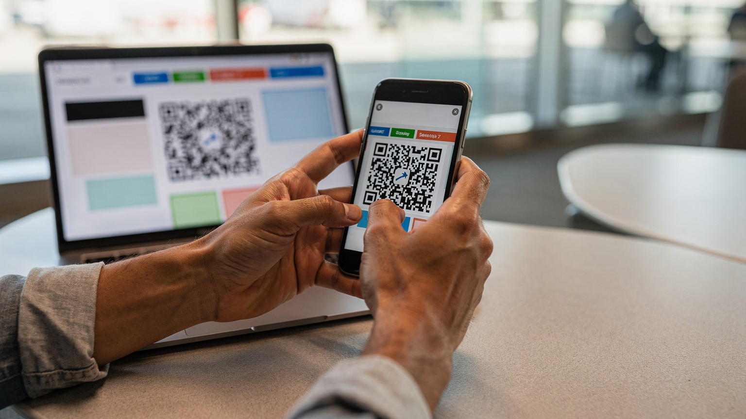 Een close-up van handen die een eSIM QR-code scannen op een smartphonescherm, met een laptop op de achtergrond die vluchtinformatie toont, wat de eenvoudige activatie benadrukt.