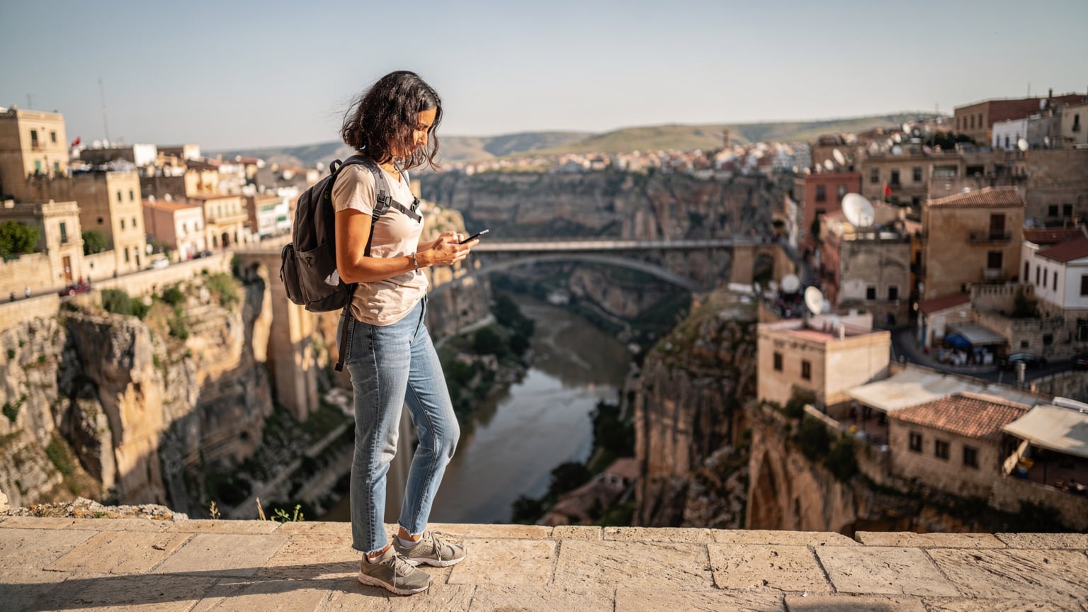 A traveler in Algeria confidently checking their phone, ensuring their eSIM is active and providing reliable connection amidst their journey.