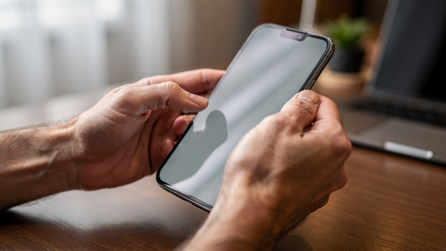 Un primo piano di mani che tengono uno smartphone, con il dito indice che scorre sullo schermo, suggerendo l'interazione con un'app o l'attivazione di un servizio come l'eSIM.