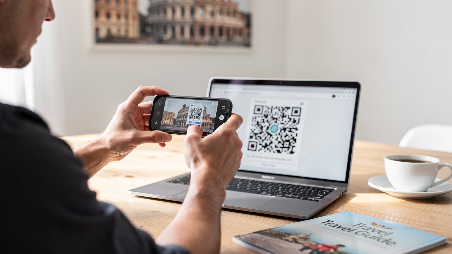 Nærbilde av en person som skanner en QR-kode på en e-post for å aktivere et eSIM på smarttelefonen sin, hjemme ved et kjøkkenbord, foran en bilde av en europeisk by.
