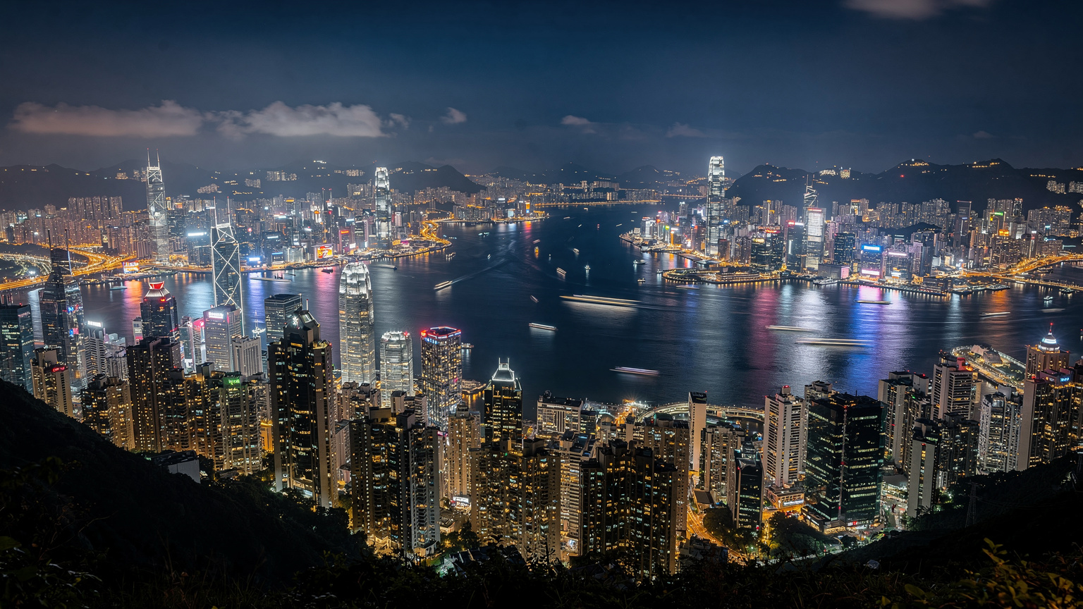 俯瞰香港維多利亞港的夜景，高樓大廈燈火璀璨，展現了這座城市充滿活力的商業氛圍。