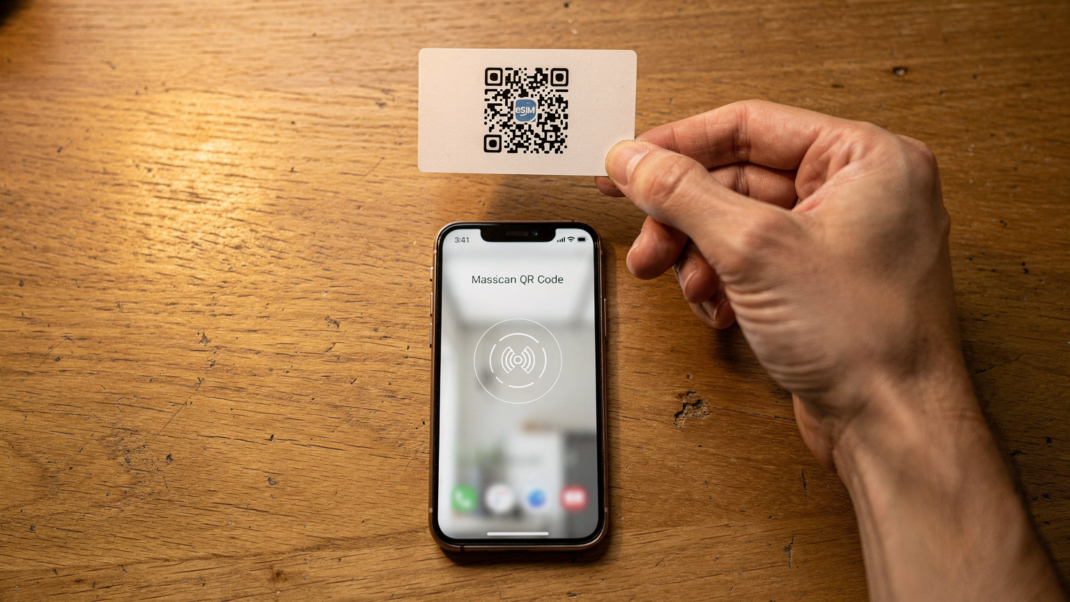 Een close-up van een QR-code voor eSIM-activatie op een papieren kaartje, gehouden boven een open Samsung Galaxy S26 op een houten tafel, met de focus op de code en het scherm.