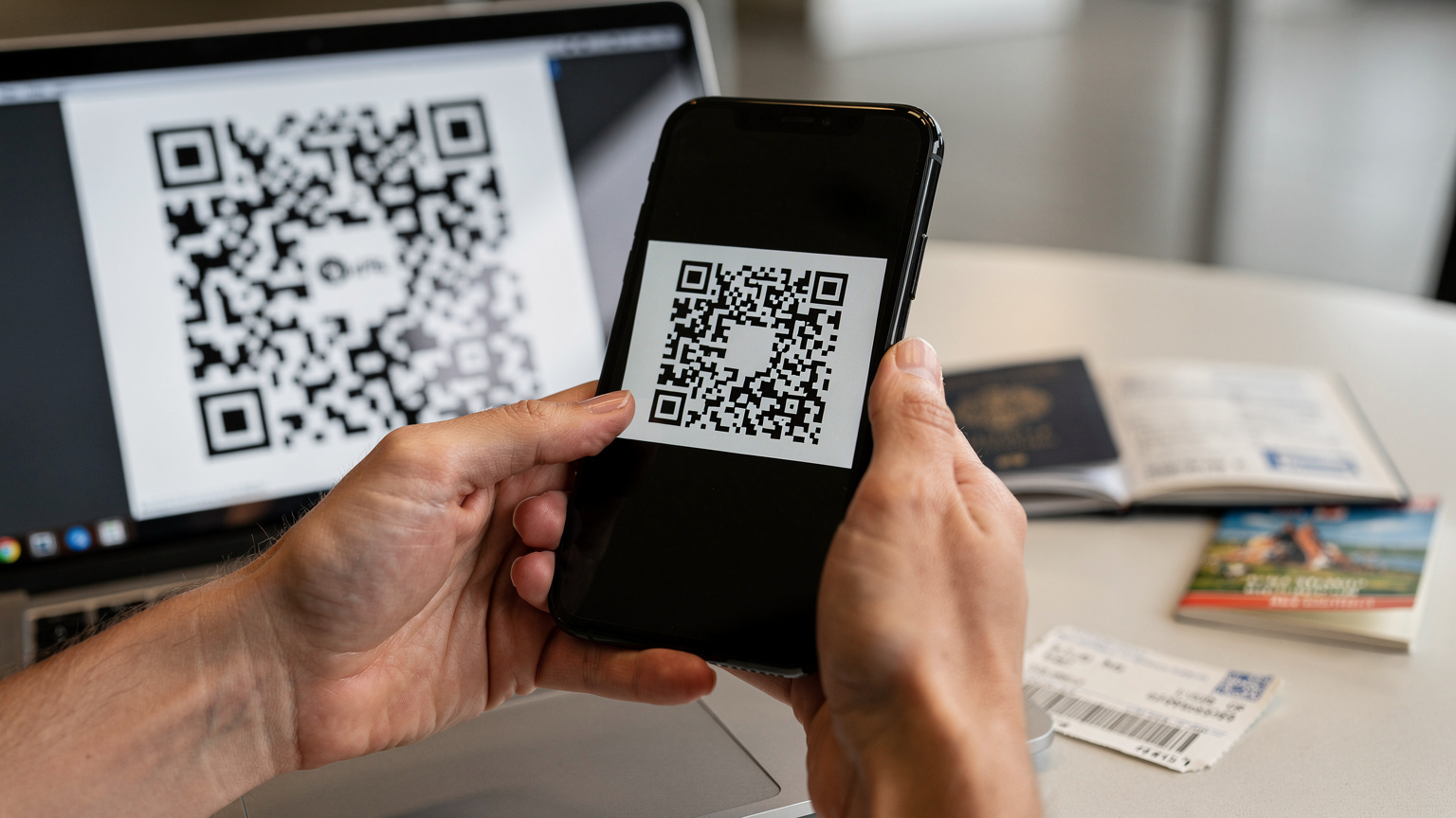 Mãos de uma pessoa segurando um smartphone, escaneando um código QR para ativar um eSIM, com um passaporte e um bilhete de avião desfocados ao fundo.
