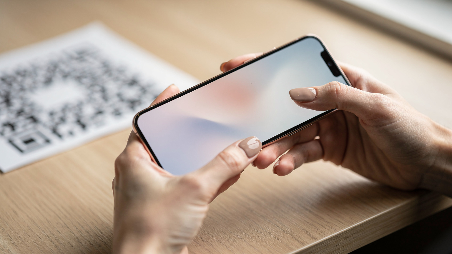 Une main féminine tenant un smartphone affiche un écran de confirmation d'activation eSIM, avec un QR code flou en arrière-plan, symbolisant la simplicité et la rapidité du processus.