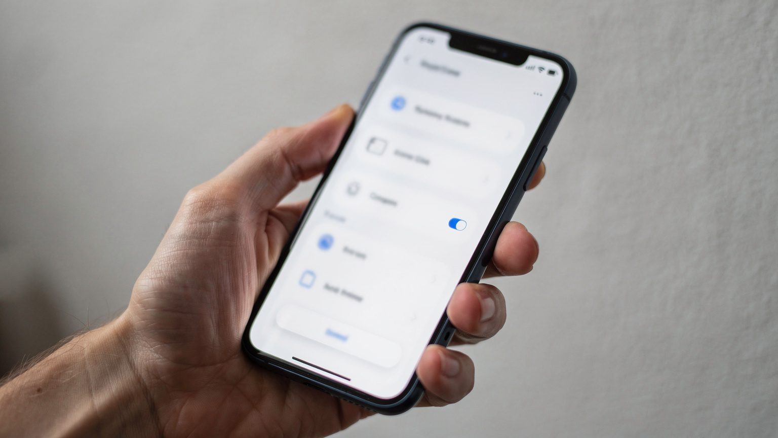 O mână apropiată ține un smartphone, cu ecranul luminat afișând setările de rețea mobilă, într-un mod discret și funcțional, fără a dezvălui detalii specifice ale interfeței.