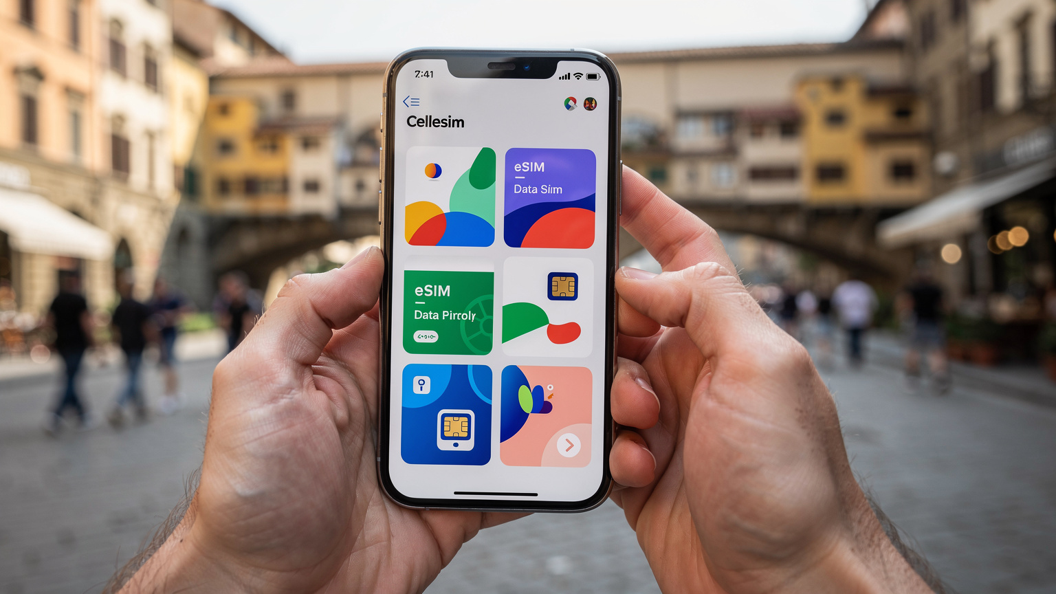 Руки держат смартфон с открытым приложением Cellesim, на экране которого отображаются тарифные планы eSIM для Италии, а на заднем плане видны улицы Флоренции.